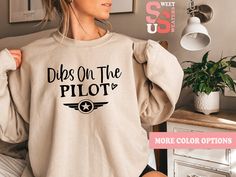 a woman wearing a sweatshirt with the words dips on the pilot printed on it