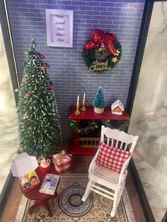 a miniature christmas scene with two chairs and a small tree in front of a brick wall