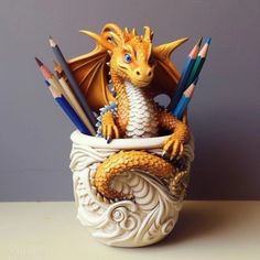 a dragon figurine sitting in a cup filled with pencils