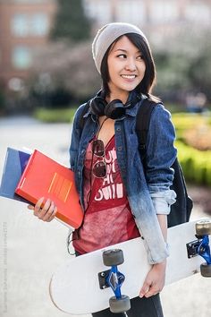 a young woman holding a skateboard and carrying shopping bags