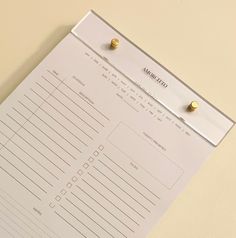 a close up of a piece of paper on a table with two pins attached to it