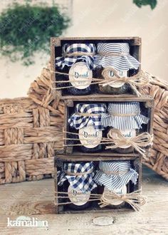 three wooden crates with blue and white gingham napkins in them on a table