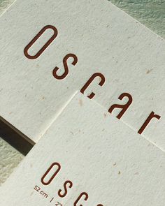 two business cards sitting on top of each other with the word oscar printed on them