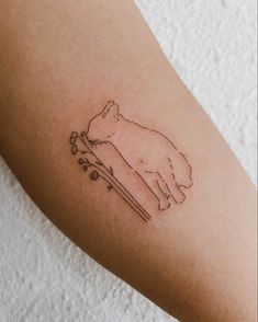 a cat tattoo on the arm with flowers and an arrow in front of its head