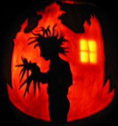 a carved pumpkin with the silhouette of a person holding a knife