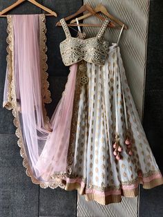 This beautiful ivory butti georgette lehenga with a ruffle shimmer and blush pink border is paired with our signature mirror and pearl hand embroidered bustier. This outfit is completed with a blush pink sequenced butti work dupatta with a scallop border. Transitional Floor-length Choli With Gota Work, Wedding Choli With Gota Work For Navratri, Wedding Saree Set With Gota Work, Traditional Drape Sets With Gota Work For Wedding, Wedding Sets With Gota Work And Traditional Drape, White Art Silk Choli For Wedding, White Kundan Lehenga For Party, Fitted Lehenga With Gota Work For Wedding, Fitted White Kundan Choli