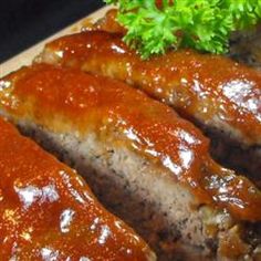 meatloaf covered in sauce and garnished with parsley on a cutting board