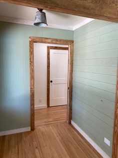 an empty room with wood flooring and blue walls