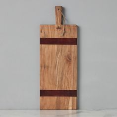 a wooden cutting board sitting on top of a counter next to a white and gray wall