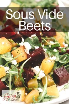 a white plate topped with beets and feta cheese on top of green leafy salad