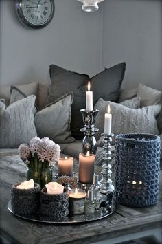 a living room filled with lots of furniture and candles on top of a table in front of a couch