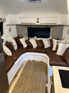 the inside of an airplane with lots of pillows on it's seat and couch