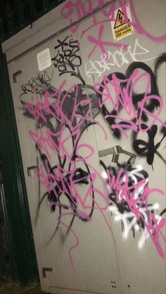 graffiti is spray painted on the side of a door in an area that has been vandalized