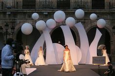 a model walks down the catwalk at a fashion show in front of an audience