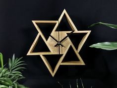 a wooden clock that has been designed to look like a star of david on the wall