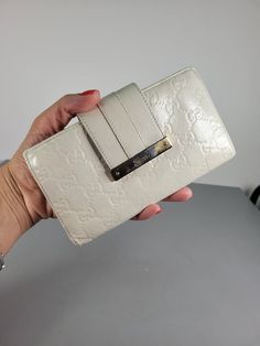 This Gucci wallet is a vintage piece that will add a touch of luxury to your accessories collection. The cream leather purse features the iconic GG monogram pattern with a white logo accent. It is suitable for women and comes in one size with a length of 18 cm (7.1") and width of 10.2 cm (4").   The wallet has a classic design and is made in Italy with high-quality materials. It includes credit card slots as a feature and is perfect for use as a purse or a wallet. Condition: Good condition. The Gucci Classic Wallets With Logo, Luxury Cream Leather Wallet, Classic Gucci Wallets With Logo, Gucci Wallet White, Wallet Vintage, Gg Monogram, Monogram Pattern, Clip Wallet, Accessories Collection