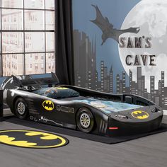 a batman car bed is shown in front of a window with the moon behind it