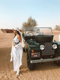 a woman standing next to an old car in the desert with text that reads, i found