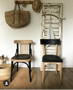 two wooden chairs in front of a white door with a black leather seat and back