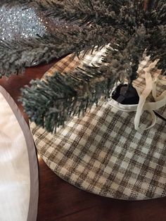 a pair of black shoes sitting on top of a wooden table next to a christmas tree