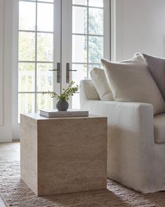 a white couch sitting next to a window in a living room on top of a rug