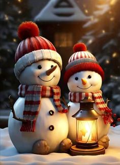 two snowmen standing next to each other in the snow with a lantern on top