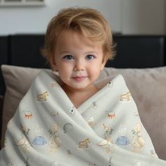 a young child wrapped in a blanket on a couch