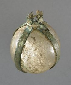 an old silver ornament with a green ribbon hanging from it's side