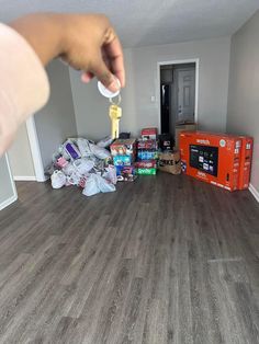 a person is holding a key in the middle of a room filled with boxes and other items