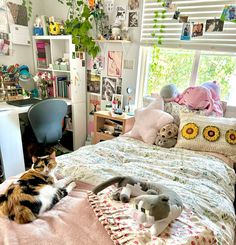 a cat laying on top of a bed in a bedroom next to a computer desk