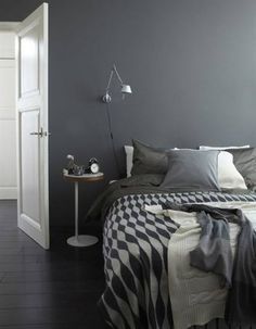 a bedroom with gray walls and white trim on the headboard, bedding and pillows