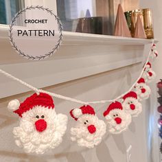 crochet santa clause garland hanging on the mantle with red and white balls attached to it