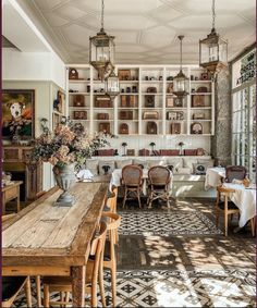 a dining room filled with lots of tables and chairs next to a wall covered in bookshelves