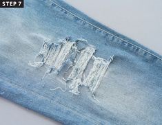 an old pair of jeans with holes in the side and torn off fabric on top