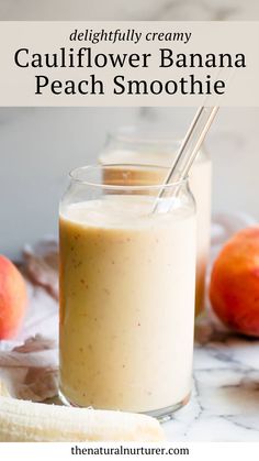 a glass filled with peach smoothie next to two bananas and an orange on the side