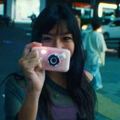 a woman taking a photo with her pink camera