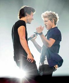 two young men standing next to each other on stage