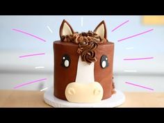 a cake decorated with a horse's head on top of a wooden table next to a wall