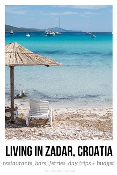 a white chair sitting on top of a sandy beach next to the ocean with boats in the water