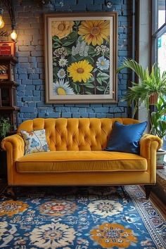 a yellow couch sitting in front of a blue brick wall next to a potted plant