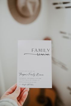 a person holding up a white card with the word family reunion written on it in black ink