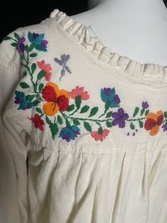 "1970's cream cotton tunic top with colorful embroidered flowers. Great vintage condition, three quarter sleeves Women's small 36\" bust 40\" max waist 24.75\" shoulder to hem 14\" back shoulders" Cream Cotton Blouse With Floral Embroidery, Spring Folk Style Cream Blouse, Folk Style Cream Tops With Floral Embroidery, Folk Style Cream Top With Floral Embroidery, Cream Folk Tops With Floral Embroidery, Spring Hippie Blouse With Floral Embroidery, Cream Long Sleeve Peasant Top With Floral Embroidery, Vintage Multicolor Blouse With Floral Embroidery, Vintage Multicolor Floral Embroidered Blouse