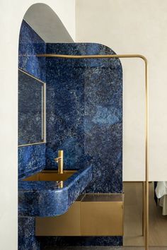 a bathroom with blue marble and gold fixtures