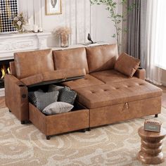 a living room with a couch, ottoman and fireplace in the corner on carpeted flooring