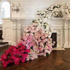 a bunch of flowers that are sitting on the floor in front of a fire place