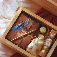 an open wooden box with various items in it