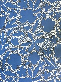 a blue background with white flowers and dots in the shape of circles on top of it