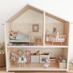 a doll house with furniture and accessories on the floor in front of a white wall