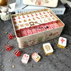 an open box filled with pink and white dices on top of a gray table