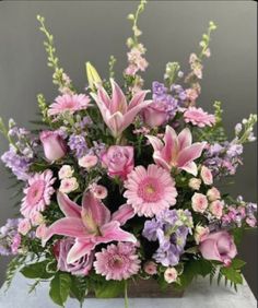 a vase filled with lots of pink and purple flowers